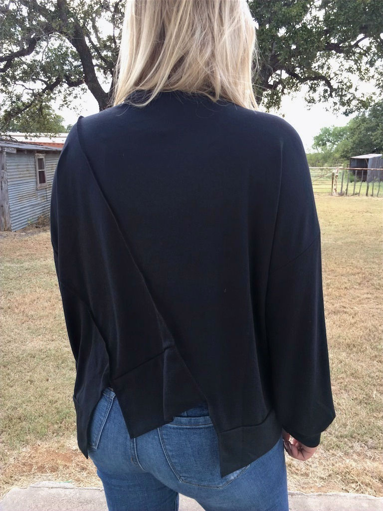 Thumbnail: Woman in black shirt shows the back with outdoor background. Laughing Crow & Crew.