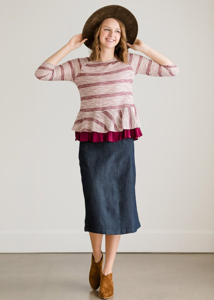 Thumbnail: Woman wearing hat and striped shirt with denim skirt, smiling.