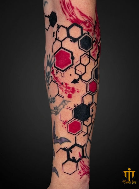 The client wanted an abstract piece to symbolize how messy events in their life still fit into a larger pattern. Solid blacks, vivid reds, and precise hexagon outlines pop against the skin, with splatter work tying old tattoos into the new design. I treated the shapes like glitching code, breaking and reconnecting them to show chaos that still holds structure.