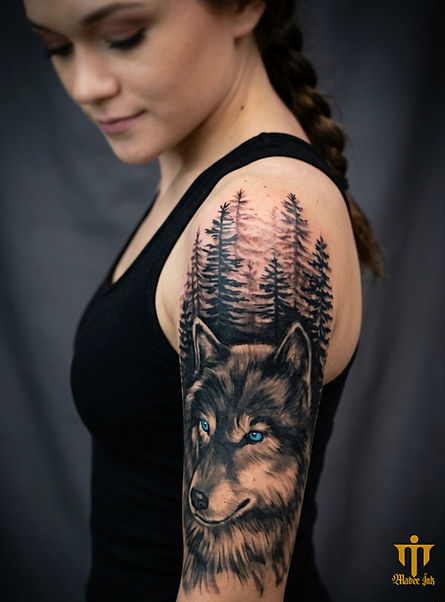The client wanted a piece symbolizing loyalty, independence, and a spiritual connection to the untamed wilderness. I focused on intricate fur detailing and used a striking, saturated ice-blue ink for the single eye to create an instant focal point against the dark treeline. I stacked the dense forest silhouettes above the wolf to evoke a mysterious, guardian-like presence that feels both calm and fierce.
