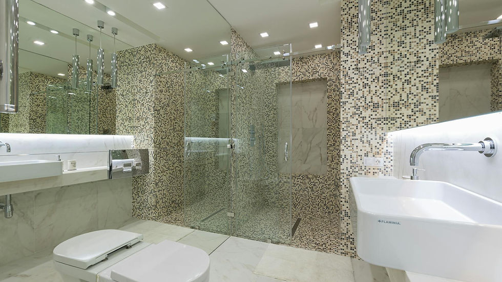 A sleek and spacious modern bathroom featuring elegant mosaic tiles and a glass shower.
