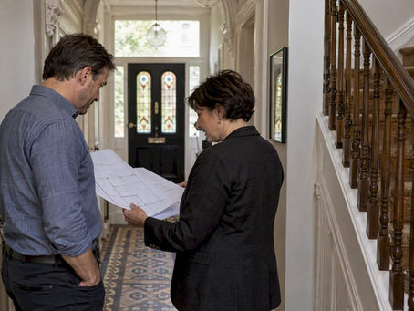 Architect and homeowner reviewing listed building plans