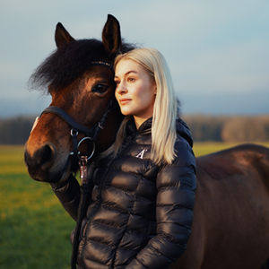 Woman with a horse on a field