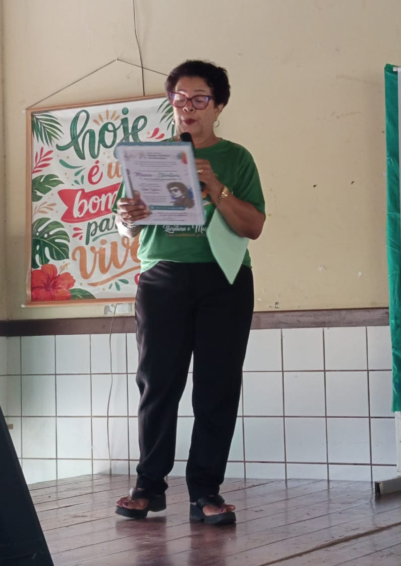 A professora Maria do Carmo realiza a apresentação das atividades que serão desenvolvidas durante a XIV Semana Literária Maria Firmina dos Reis.
