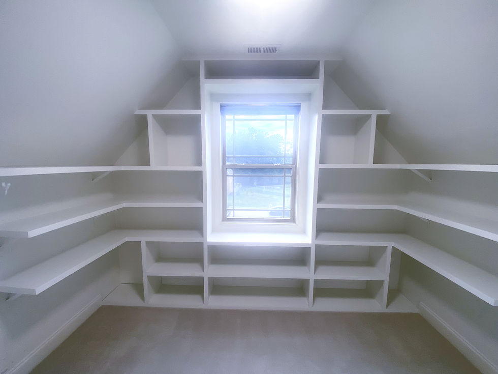 Custom storage system in attic bonus room designed to fit sloped walls