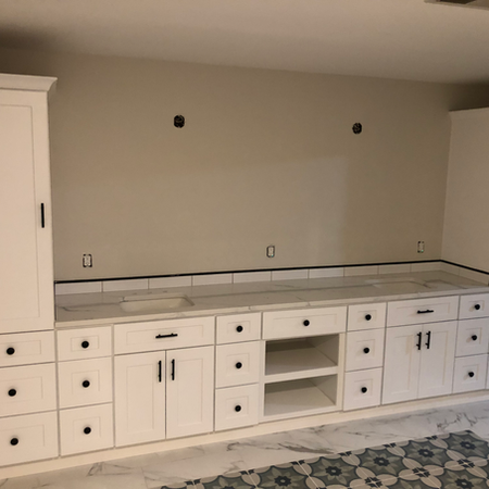 Full-height custom storage tower integrated into a bathroom vanity.