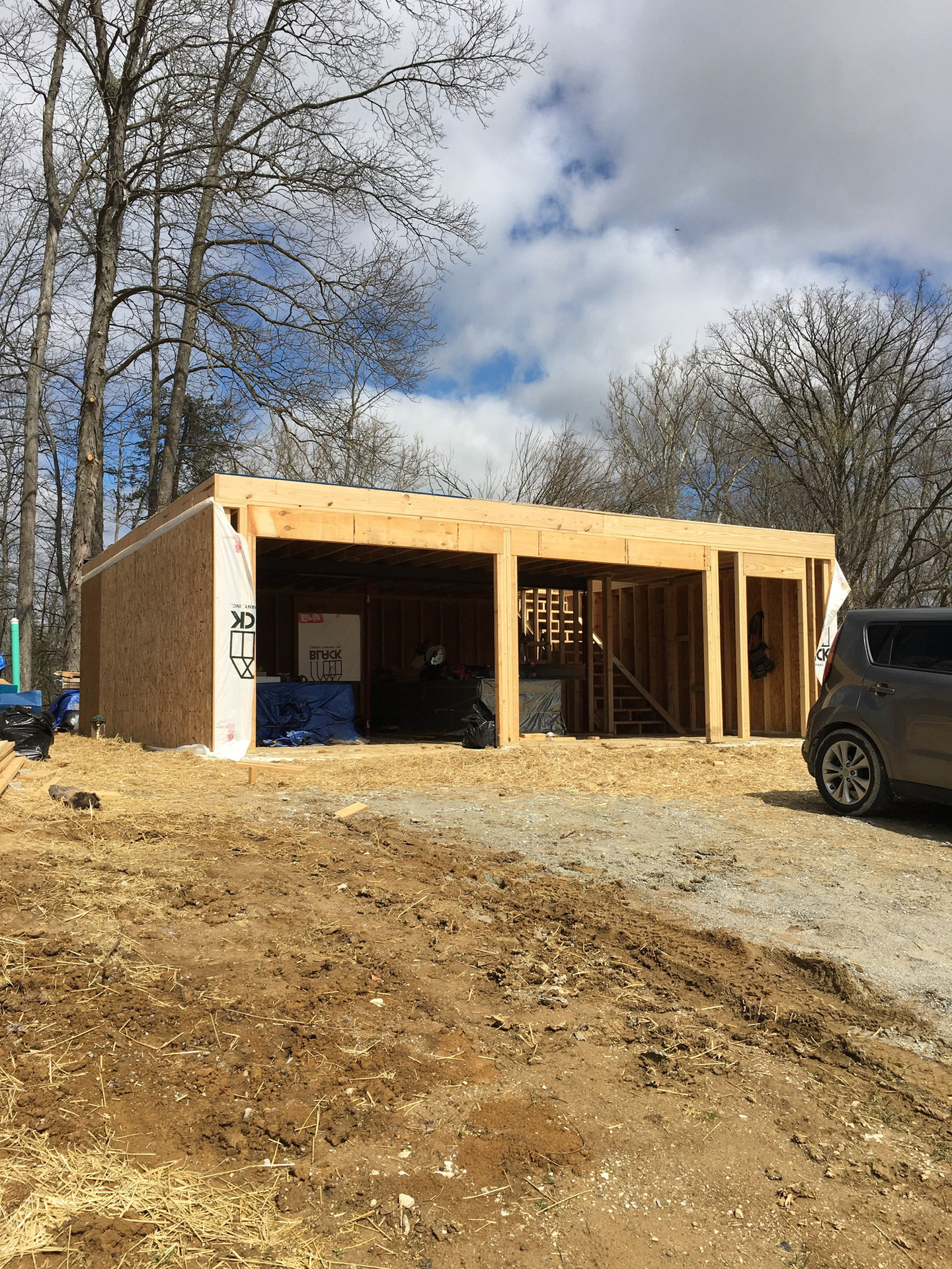 Building construction with open garage doors and wooden frame Fuller Center For Housing of Putnam Co