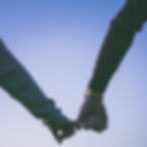 two arms holding hands by the pinky fingers