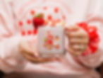 Person holding a strawberry shortcake mug