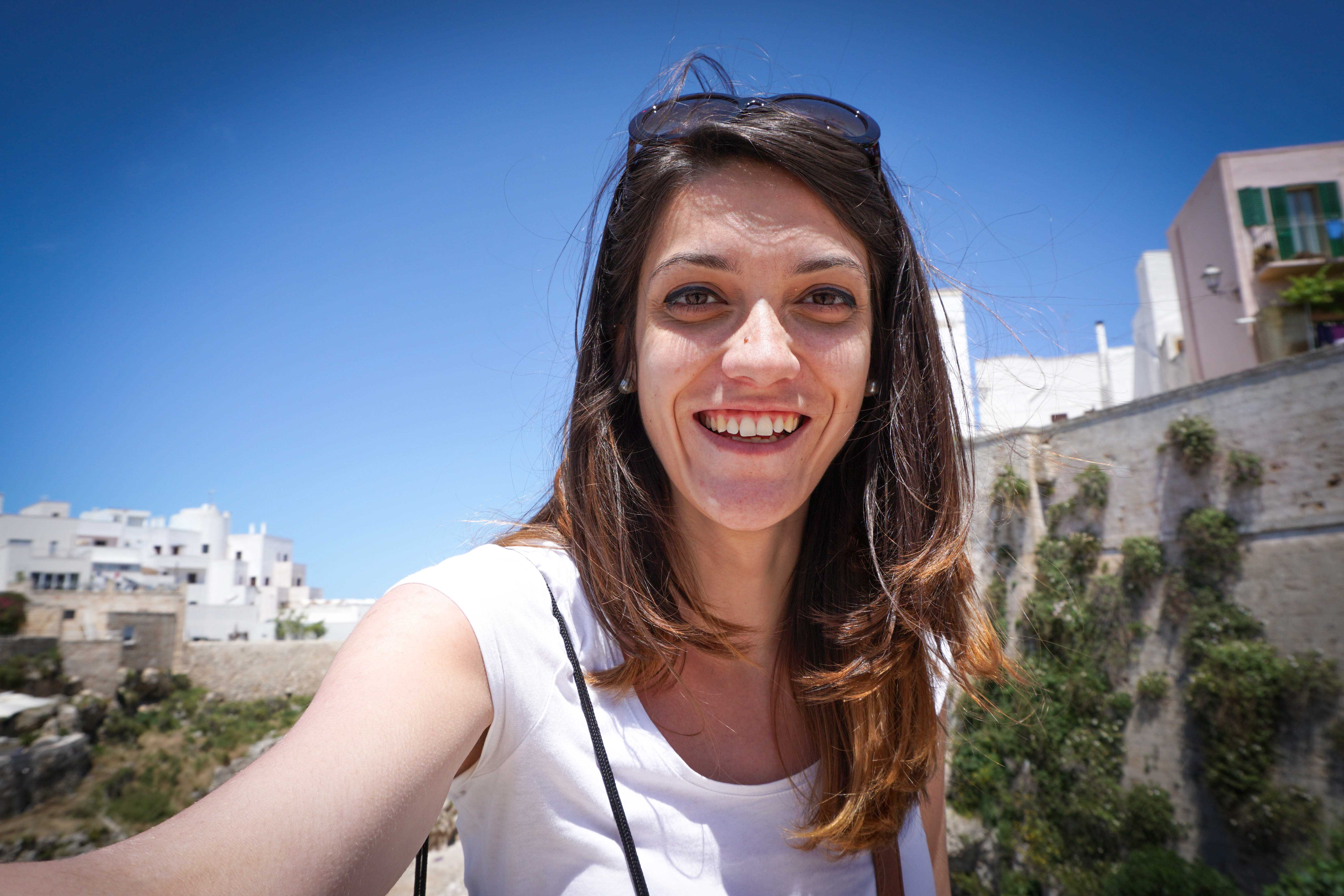 portrait-smiling-young-woman-against-clear-blue-sky-city.jpg
