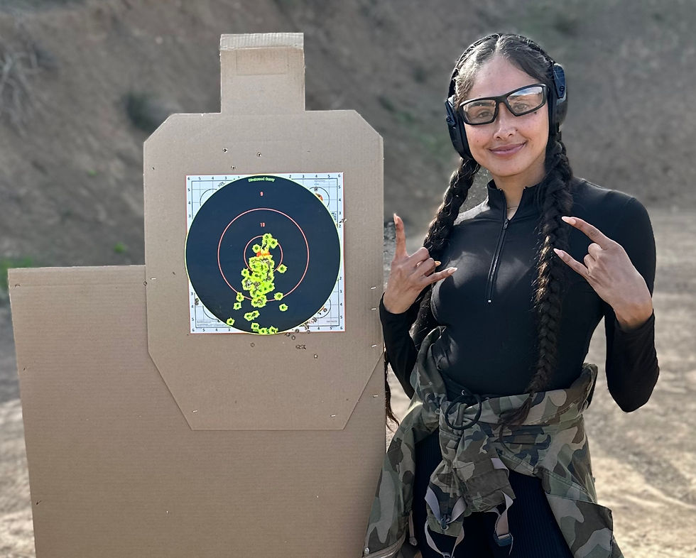 Woman standing next to target after learning how to shoot her gun safely and more accurately