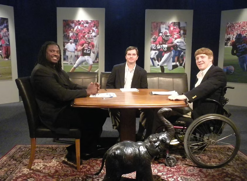 Mike Parker on the Crimson Cover studio set with fellow hosts