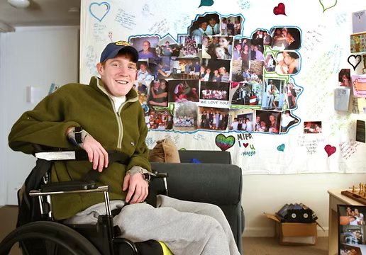 Mike Parker smiling in his wheelchair at home