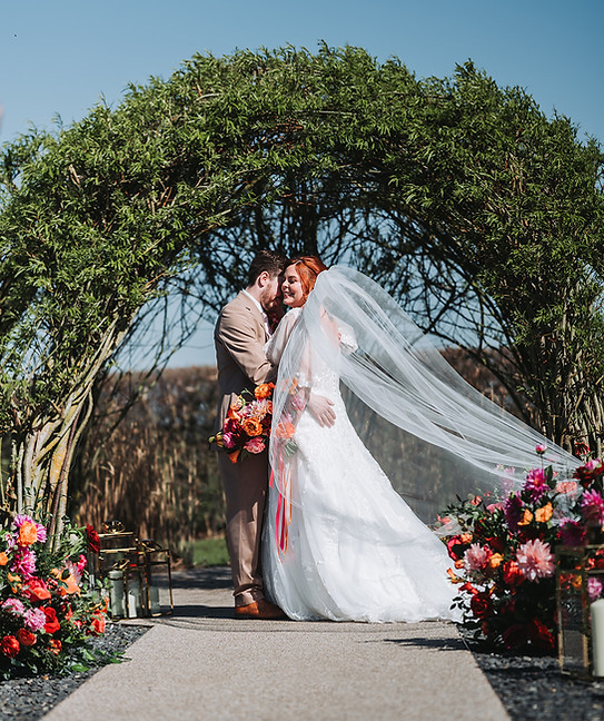 Bride & groom outside ceremony with veil
