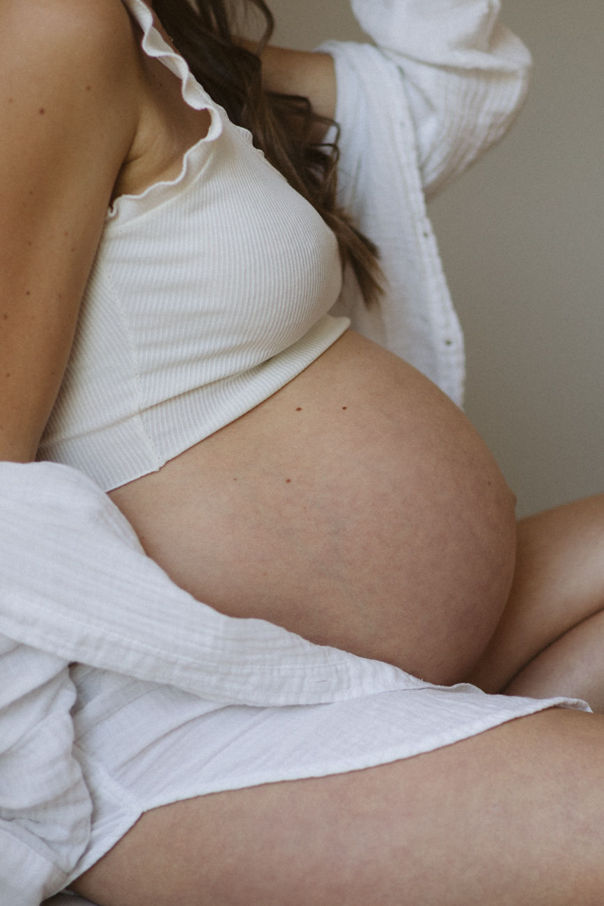 Schwangere Frau in Unterwäsche und Hemd