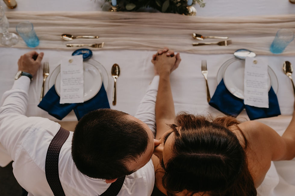 Overhead shot of bride and groom kissing at head table. Photographed by Nicole Leanne Photography.