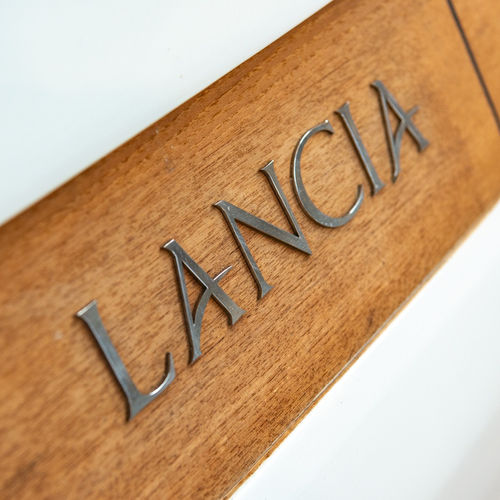 Lancia Aprea logo op teak houten paneel