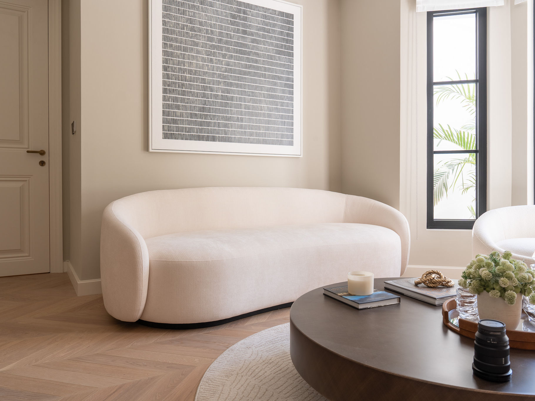 Lunara Curved Sofa in Dubai with soft rounded upholstery, curved backrest and neutral fabric in a modern living room by Adams