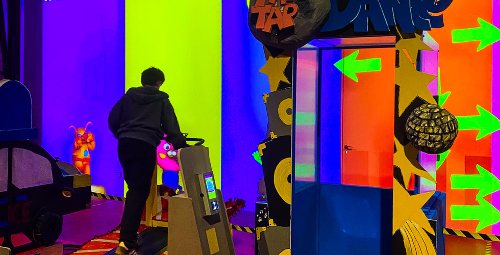 View of the MISSION FRISSON installation in the Grande Halle at LUMA Arles, featuring sports and recreational structures and artistic elements.