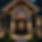 custom home view from side and black exterior potlights with visual chandelier through win