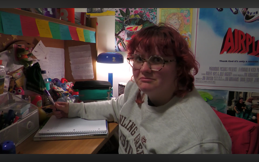 Girl sitting at desk writing in a notebook.