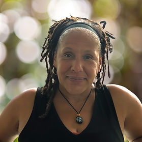 Portrait of Carmen Hubbard, a warm and grounded therapist and Reiki practitioner, sitting in a calm space that reflects her holistic, healing approach.