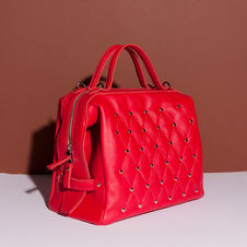 Deze tas is een variatie op de beugeltas. Bij deze beugeltas gebruik je 2 dezelfde lengte beugels en gaat de tas open met een rits in het ritsdak. De panden zijn versiert met de capitonneer techniek.