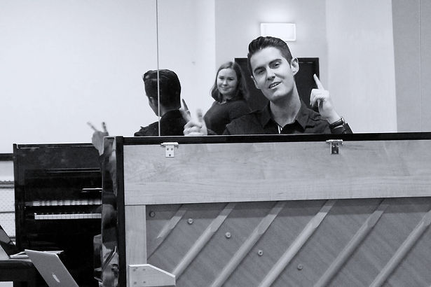 Matthew Lee Robinson leading a vocal masterclass from a piano.