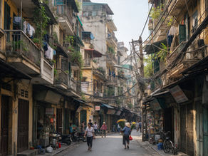 Hanoi Old Quarter street with French colonial buildings and motorbikes in the morning.