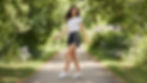Female model outdoors walking casually in a parkway wearing Casmir shorts made for training and casual wear.