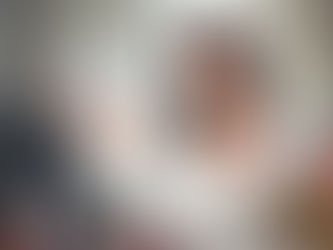 Indian Woman applying makeup with a brush, holding a palette in the other hand.