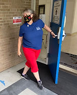 Retired School Personnel holding the door open to a school while deliver PPE kits to support our public school educators and students.
