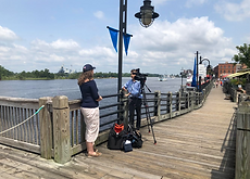 Woman on the Wilmington, NC, Cape Fear riverfront speaking to a reporter about pollution concerns.
