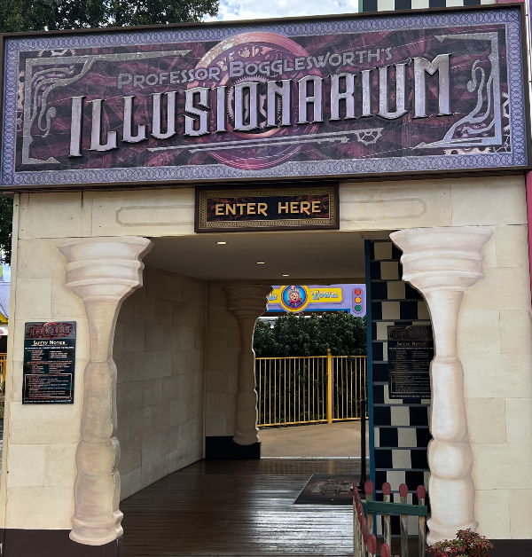 Entrance to Professor Boggleworth's Illusionarium with a large sign. Decor includes painted columns, a checkerboard pattern, and "Enter Here" text.