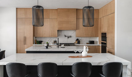 Mid-century modern flat-panel wood kitchen cabinets with thick marble waterfall countertops in Asheville, NC.