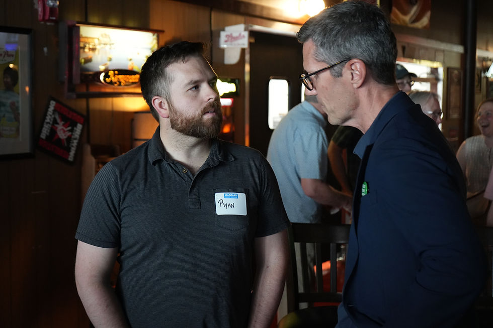 Maine Speaker of the House Ryan Fecteau speaks with an attendee during town hall event