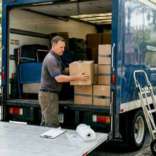 Mover loading boxes into small moving truck