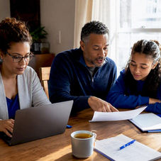 Family reviewing moving insurance paperwork at table