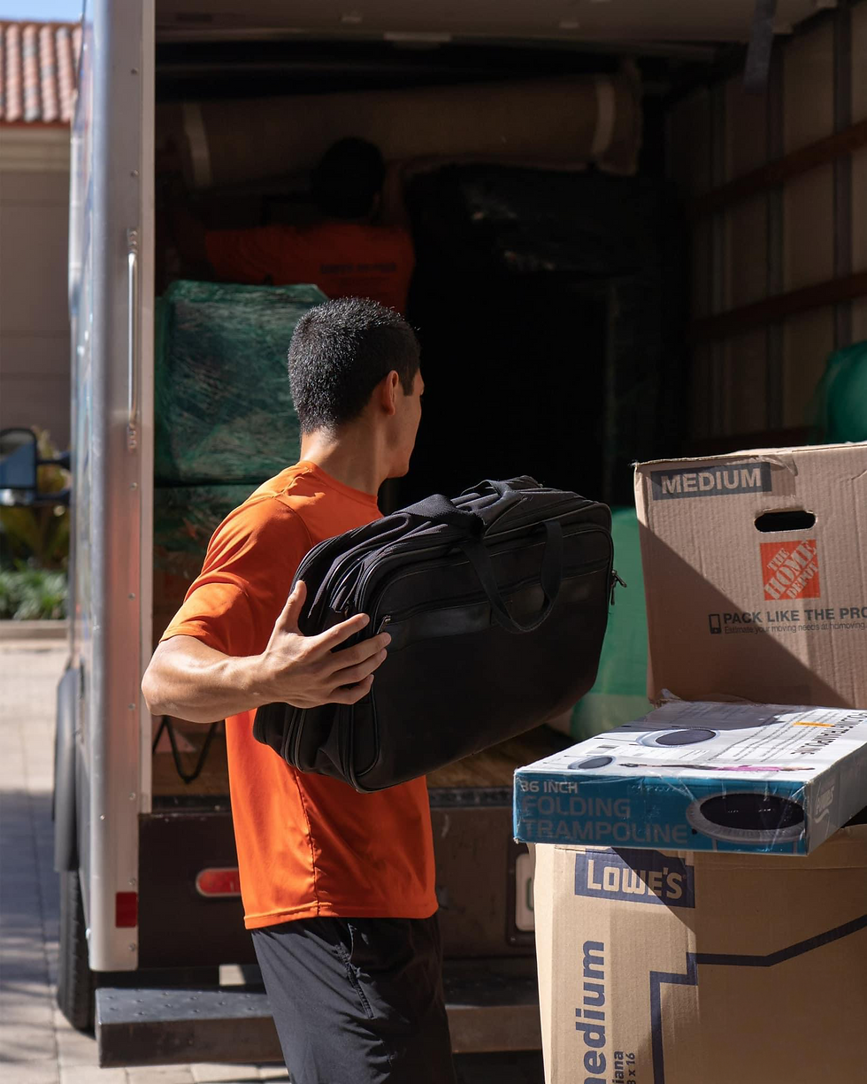 company owner placing items into moving truck