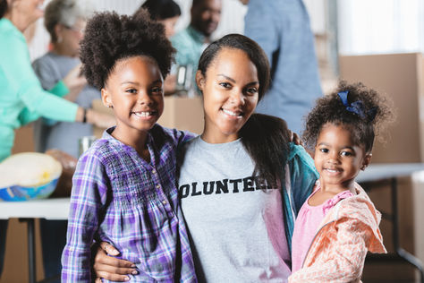 A volunteer posing with two little girls