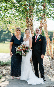 Bride, groom, and mother pose for a photo.