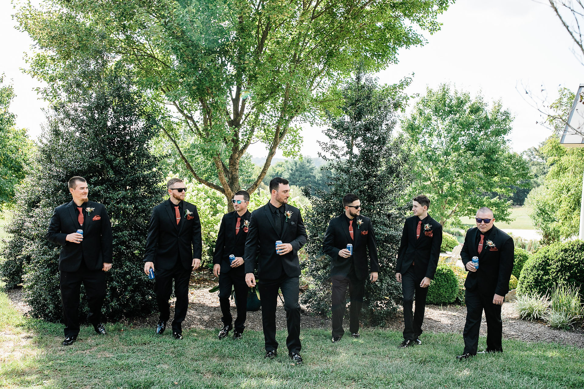 Groom and groomsmen pose for a photo in front of the trees.