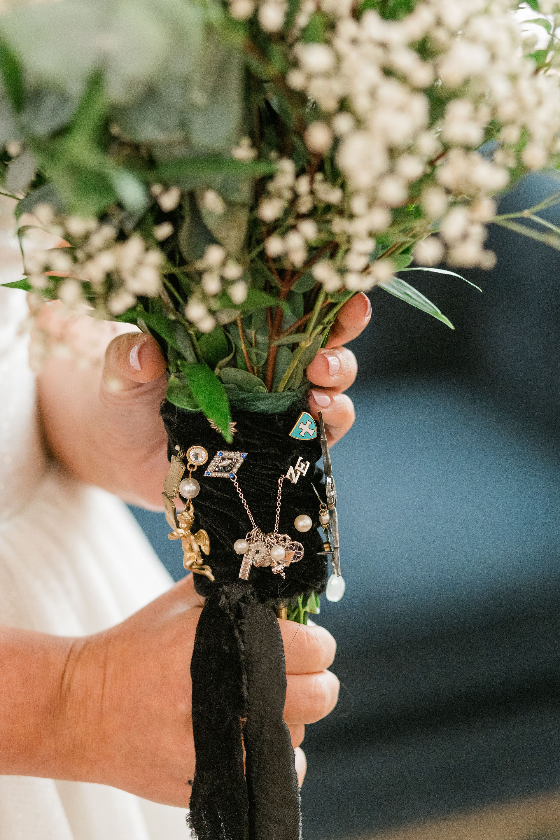 close up of a bridal bouquet with pins and charms