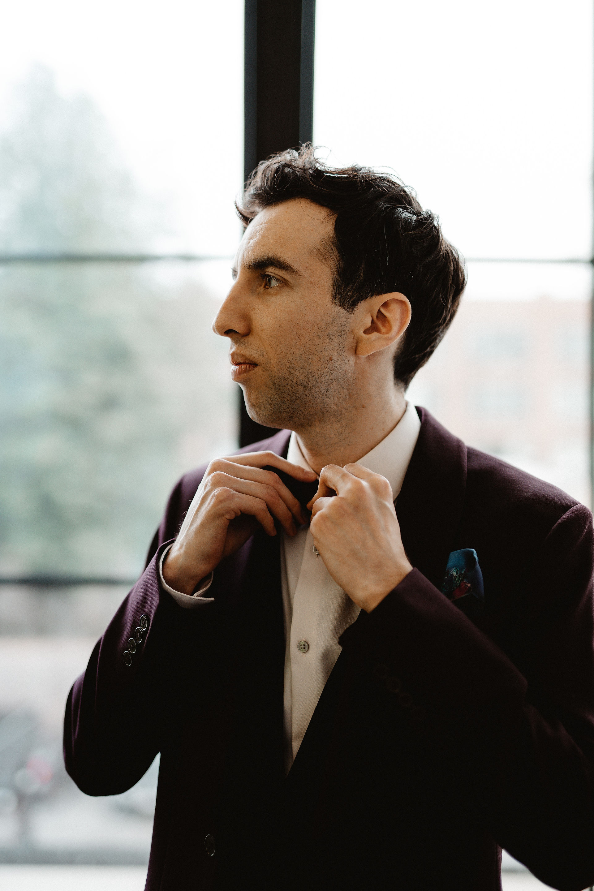 Groom adjusting his bowtie