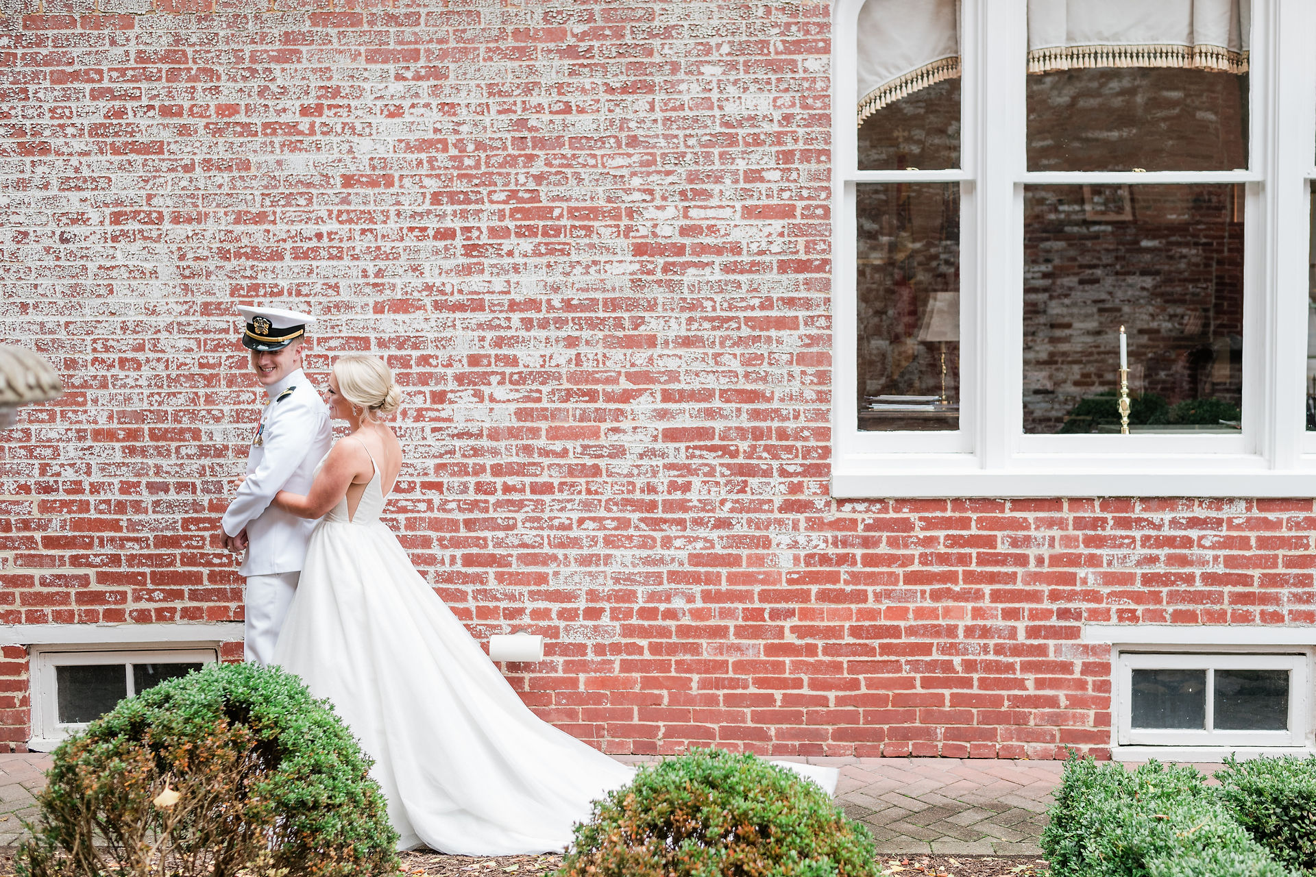 bride and groom having a moment by a brick wall