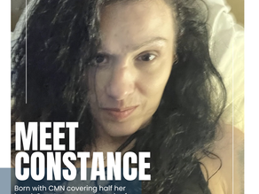 A woman with long black hair smiles up at the camera. She's wearing a cross necklace and black tank top. Half of her face is covered by her hair but very faint scarring can be seen near her eyebrow. She smirks kindly at the camera. The words "Meet Constance" appear in the bottom right corner with a written excerpt of this blog.