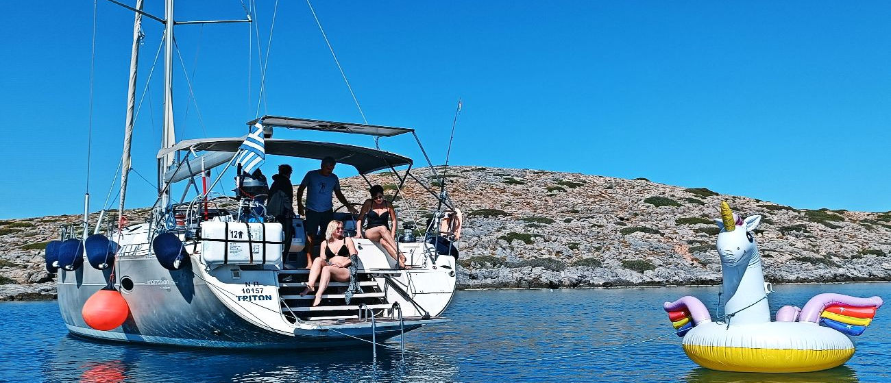People having fun at the opening swimming platform of sailboat TREATON during a sailing trip to Dia island
