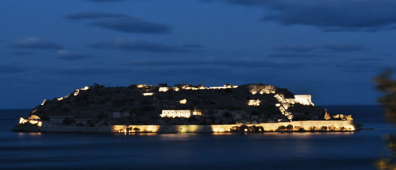 Breathtaking view of the enlightened Spinalonga island in twilight, shot during a sailing trip to Agios Nikolaos onboard sailboat TREATON
