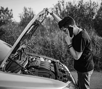 Young man looking at the engine of his car
