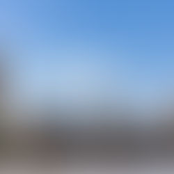 The Palace of Westminster from across the River Thames. There is a blue sky in the background and some fluffy white clouds.